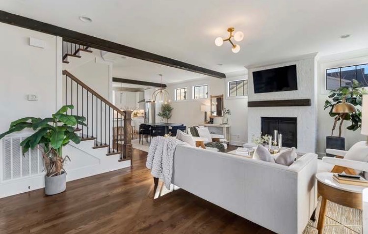 Open concept living room with white walls and wood beams